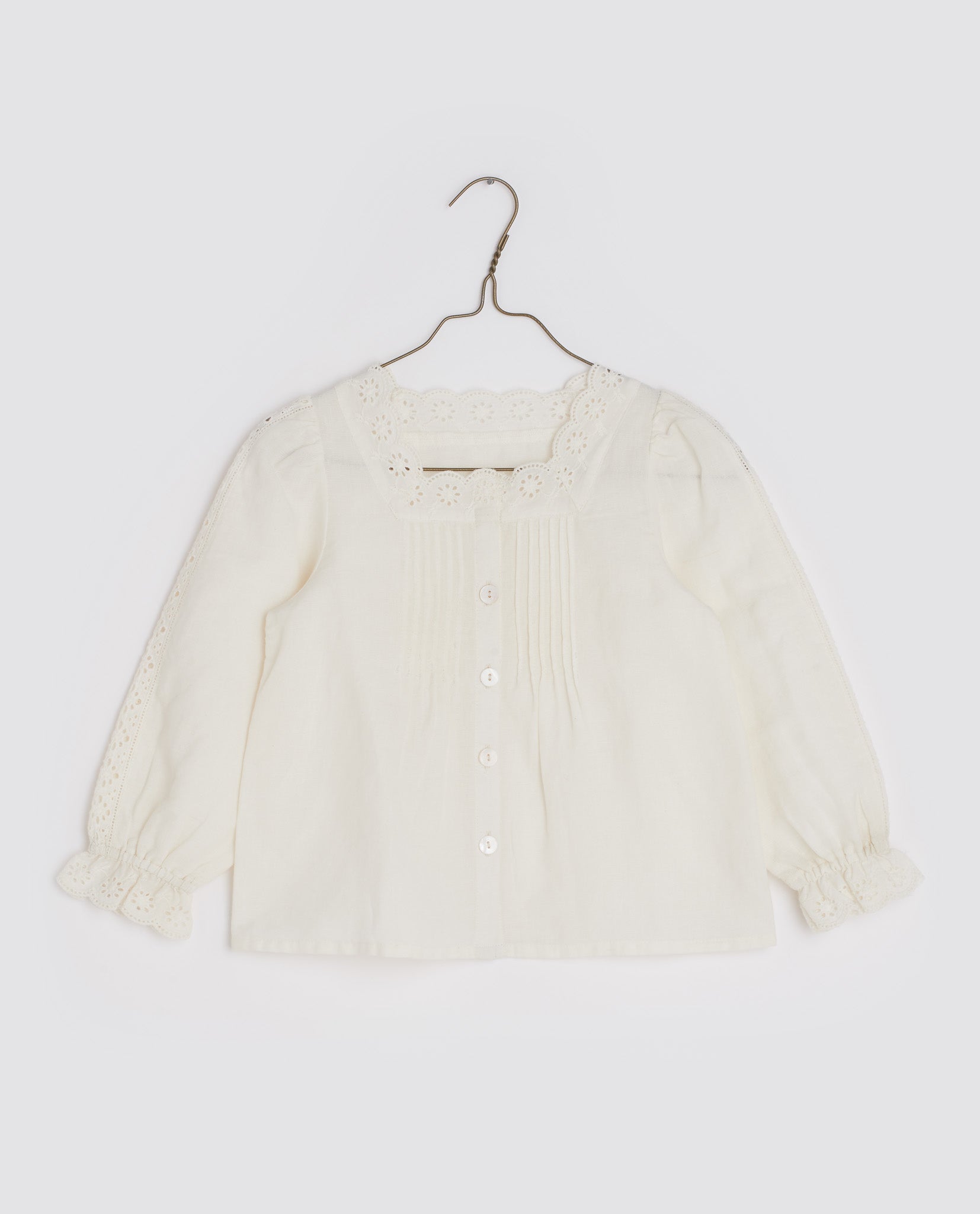 Girls scalloped collared blouse with long sleeves, buttons down the front and pleats on the chest, in the colour off white, by Little Cotton Clothes. 