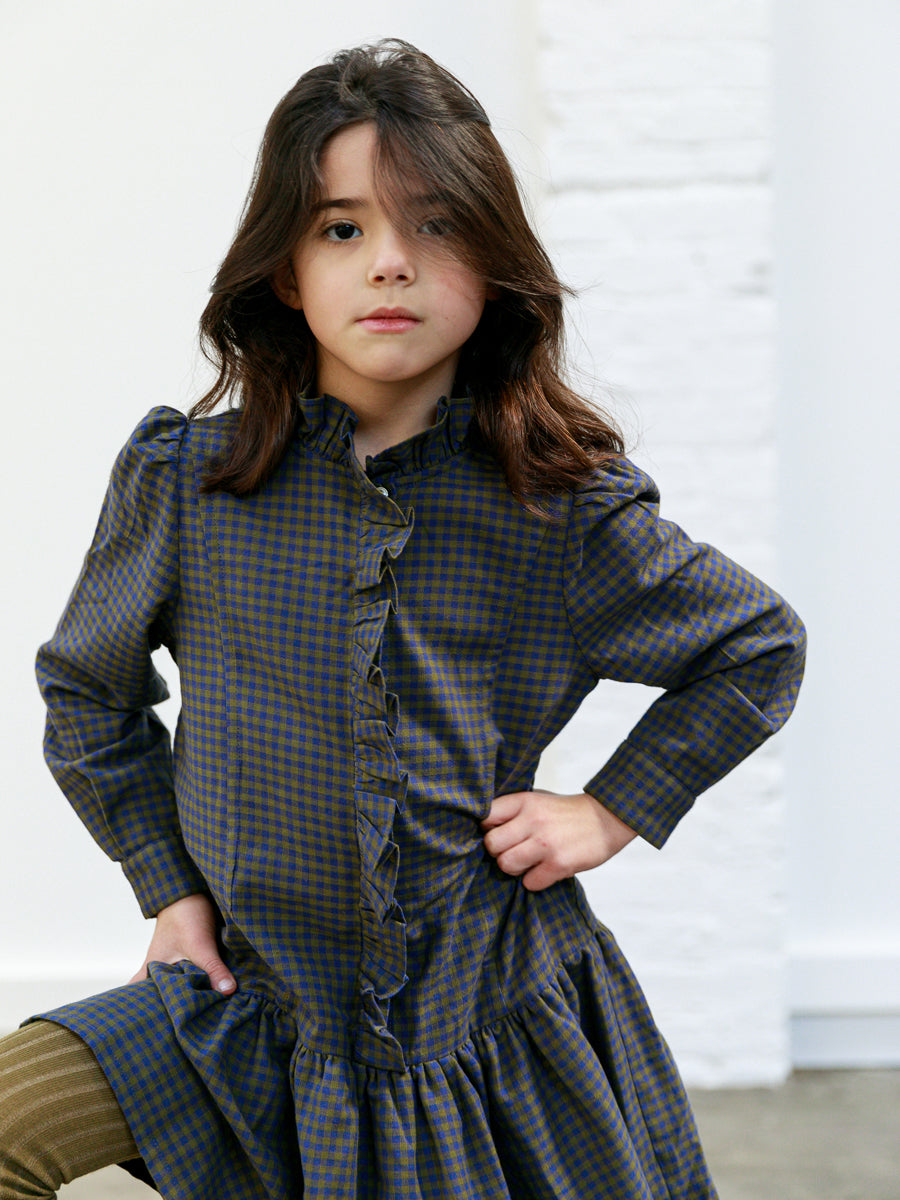 Purple check girls dress with gathered drop waist, ruffled trim down the chest and a high neck ruffled  collar. By Ketiketa