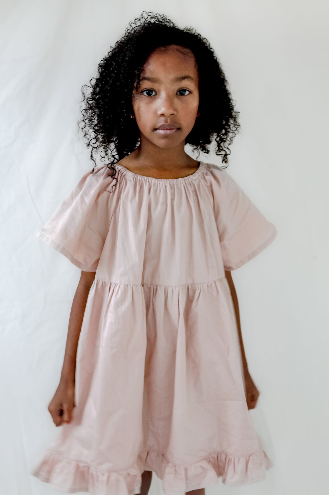 Girl wearing a Dusty Pink Dress With Bell Sleeves, Gathered Neckline, Ruffle Hem and Flowy Silhouette