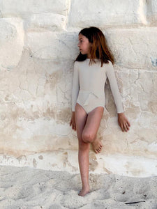 Girl wearing sustainable full cover long sleeve swimsuit by Casa Blue Swim
